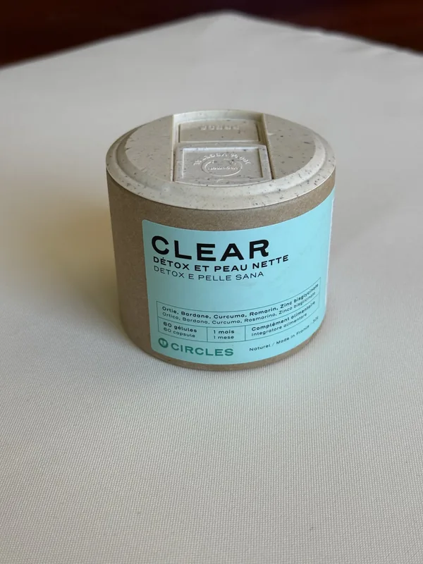 Le pot CLEAR de Circles, en carton, étiquette vert d'eau, posé sur une nappe en lin